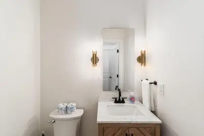 a white bathroom with a sink and a toilet at Luxury Escape 4BR 3 bath Oasis in Historic Old Town in Columbus