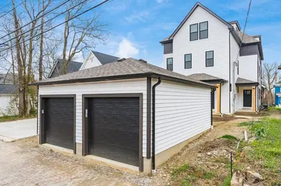 a garage with two doors in front of a house at Luxury Escape 4BR 3 bath Oasis in Historic Old Town in Columbus