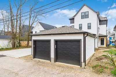 a garage with two garage doors in front of a house at Luxury Escape 4BR 3 bath Oasis in Historic Old Town in Columbus