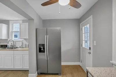 a stainless steel refrigerator in a kitchen with a ceiling fan at The Huron Charmer-4 BD and Yard in Columbus