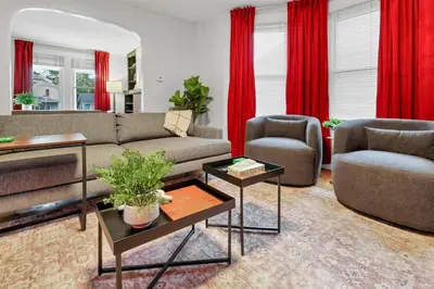 a living room with a couch and chairs and red curtains at The Ohio State of Mind 5BR 2BA in Columbus