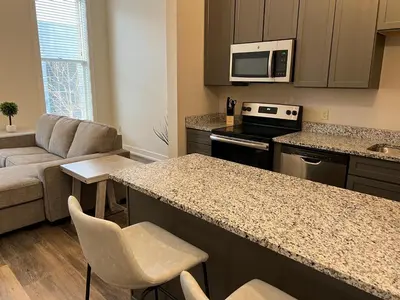 a kitchen with a counter and a living room at Strongback Suite 205 in Adrian