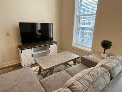 a living room with a couch and a flat screen tv at Strongback Suite 205 in Adrian
