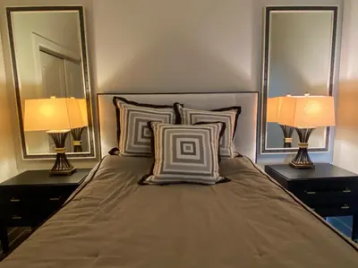 a bedroom with two mirrors and a bed with two lamps at Strongback Suite 207 in Adrian