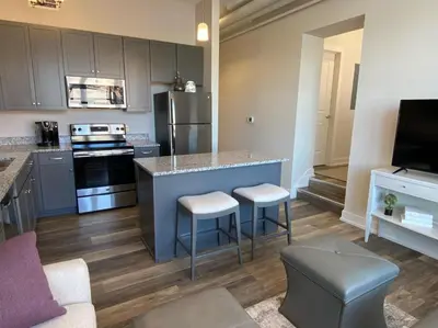 a kitchen with a counter and stools in a room at Strongback Suite 207 in Adrian