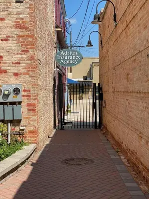 an alley with a sign on the side of a brick building at Strongback Suite 207 in Adrian