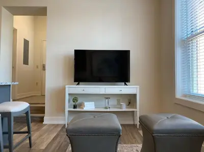 a living room with a tv and two chairs at Strongback Suite 207 in Adrian