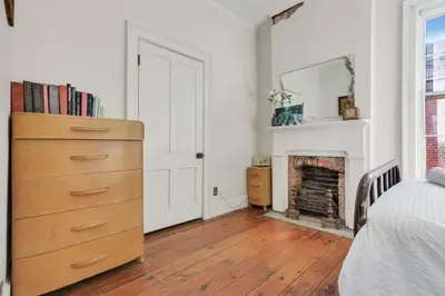 a bedroom with a dresser and a fireplace at The Retro Getaway in Columbus
