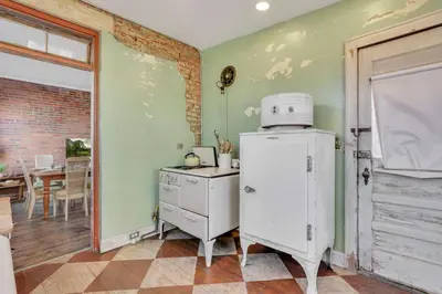 a kitchen with an old refrigerator and a table at The Retro Getaway in Columbus