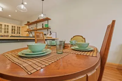 a wooden table with bowls and plates on it at The Urban Oasis - 2 BR - Great Location in Columbus
