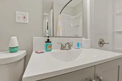 a white bathroom with a sink and a mirror at Bright and Breezy Gahanna Ranch 10min to INTEL in Columbus