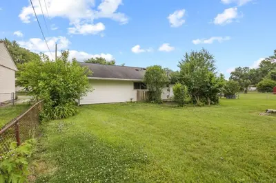 a house with a yard with a fence at Bright and Breezy Gahanna Ranch 10min to INTEL in Columbus