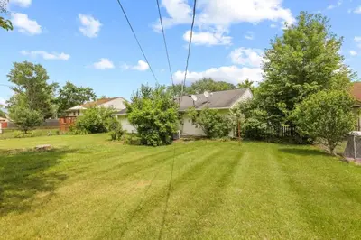 a yard with green grass and a house at Bright and Breezy Gahanna Ranch 10min to INTEL in Columbus