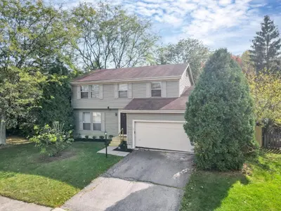 a house with a white garage and a tree at Gahanna Dreaming - 5Br 2 Ba INTEL in Gahanna