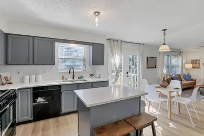 a kitchen with black and white cabinets and a living room at Gahanna Dreaming - 5Br 2 Ba INTEL in Gahanna