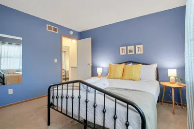 a bedroom with blue walls and a bed with yellow pillows at Gahanna Dreaming - 5Br 2 Ba INTEL in Gahanna