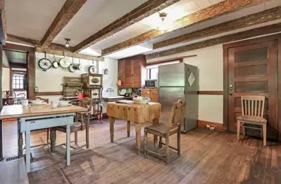 a kitchen with a table and chairs and a refrigerator at The City Cabin - Unique and Historic in Columbus