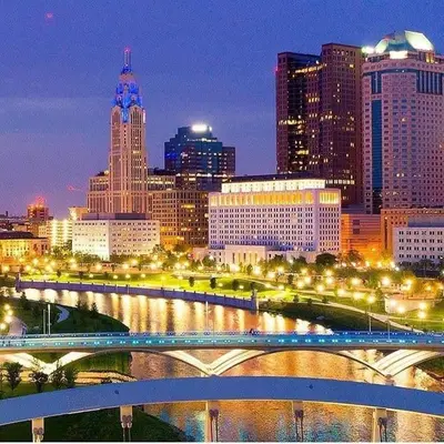 a city skyline with a bridge over a river at The City Cottage - Unique and Cozy in Columbus