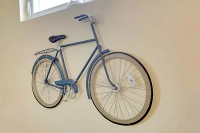a blue bike hanging on a wall at The City Cottage - Unique and Cozy in Columbus