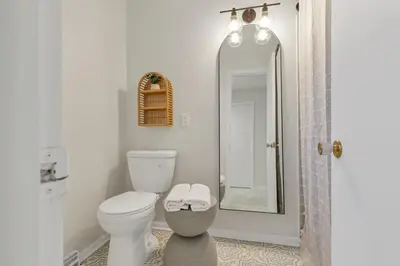 a bathroom with a toilet and a shower with a mirror at Gahanna Farmhouse - 4 Bed 2 Bath - INTEL in Columbus