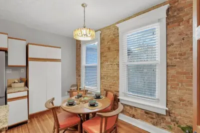 a kitchen with a table and chairs and a brick wall at The Goodale Retreat - 2 BR 2Bath in Columbus