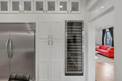 a kitchen with a refrigerator and a red couch at The Mohawk Masterpiece in Columbus