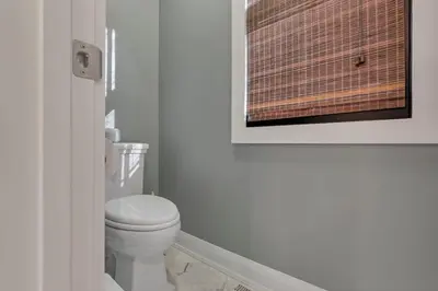 a bathroom with a toilet and a picture on the wall at The Mohawk Masterpiece in Columbus
