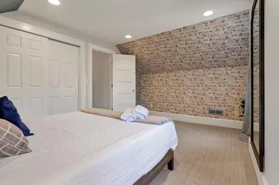 a bedroom with a brick wall and a bed at The Mohawk Masterpiece in Columbus