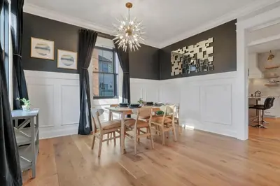 a dining room with a table and chairs and a chandelier at The Mohawk Masterpiece in Columbus
