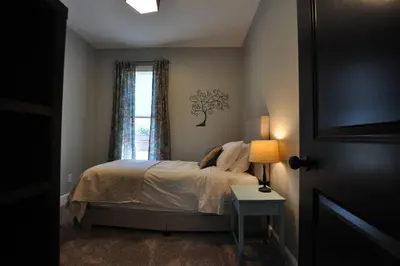 a bedroom with a bed with a tree sticker on the wall at Breath of Fresh Air - House- 3 BR 2BA in Columbus
