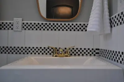 a bathroom sink with a gold faucet and a mirror at Breath of Fresh Air - House- 3 BR 2BA in Columbus