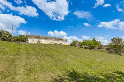 a house on top of a grassy hill at Quiet Dry Ridge Home with Yard - Near Ark Encounter! in Dry Ridge