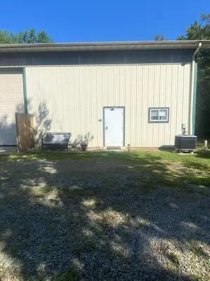 a building with a door and a bench in a yard at 102 Acre Pet Friendly Horse Farm! Bring your horse too! in Lebanon