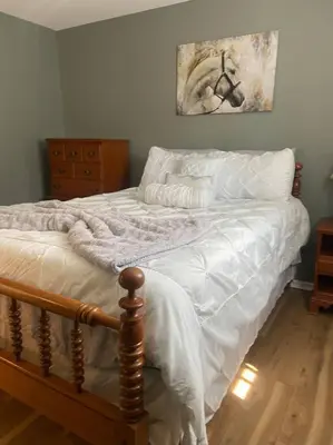 a bedroom with a bed with white sheets at 102 Acre Pet Friendly Horse Farm! Bring your horse too! in Lebanon