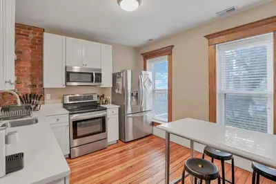 a kitchen with stainless steel appliances and white cabinets at The Goodale House - 2 Units - 4 BR 5 Bath in Columbus