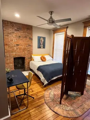 a bedroom with a bed and a brick wall at The Goodale Overlook in Columbus