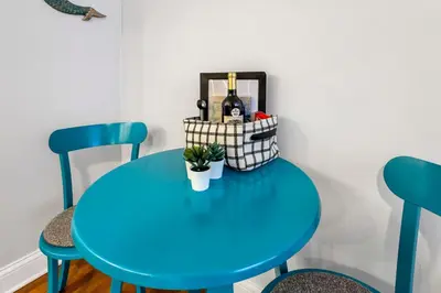 a blue table with two chairs and a bottle of wine at Cozy 2 BR in Short North Convenient Parking in Columbus