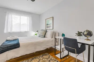 a bedroom with a bed and a table and a chair at Cozy 2 BR in Short North Convenient Parking in Columbus