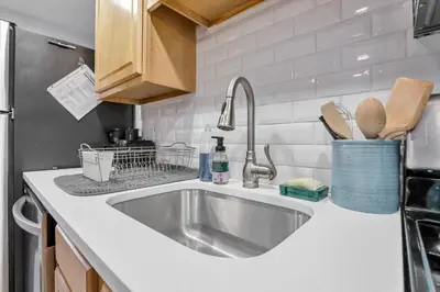 a kitchen counter with a sink and a refrigerator at Cozy 2 BR in Short North Convenient Parking in Columbus