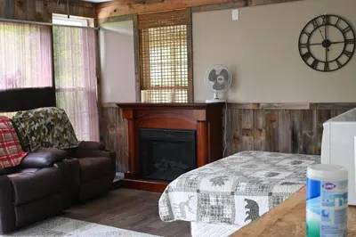 a living room with a bed and a fireplace at Cabin with Character in New Lexington