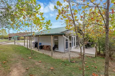 a white house with a porch and a yard at Cabin with Character in New Lexington