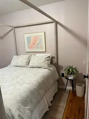 a bedroom with a bed with a white comforter at Sunny Lavender Canopy Retreat in Cleveland