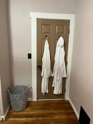 a hallway with a door with white clothes hanging on it at Sunny Lavender Canopy Retreat in Cleveland
