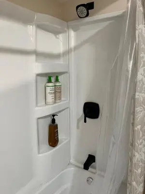 a bathroom with a bath tub with two bottles of soap at Garden Whisper Cozy Chamber in Cleveland