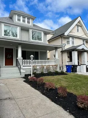 a house with a white fence in the front yard at Garden Whisper Cozy Chamber in Cleveland
