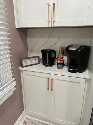 a kitchen cabinet with a coffee maker and a toaster at Stained Glass Serenity Suite in Cleveland