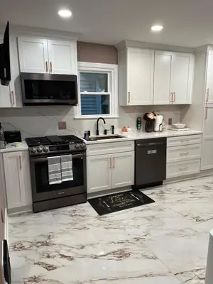 a kitchen with white cabinets and a black stove at Stained Glass Serenity Suite in Cleveland