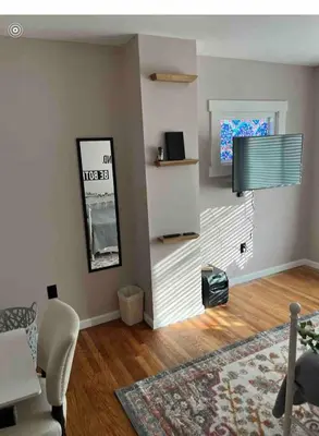 a living room with a table and a television at Stained Glass Serenity Suite in Cleveland