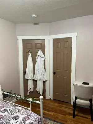 a bedroom with a bed and a door and a chair at Stained Glass Serenity Suite in Cleveland