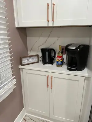 a kitchen cabinet with a coffee maker and a toaster at Elevated Entertainment Sleep Suite in Cleveland